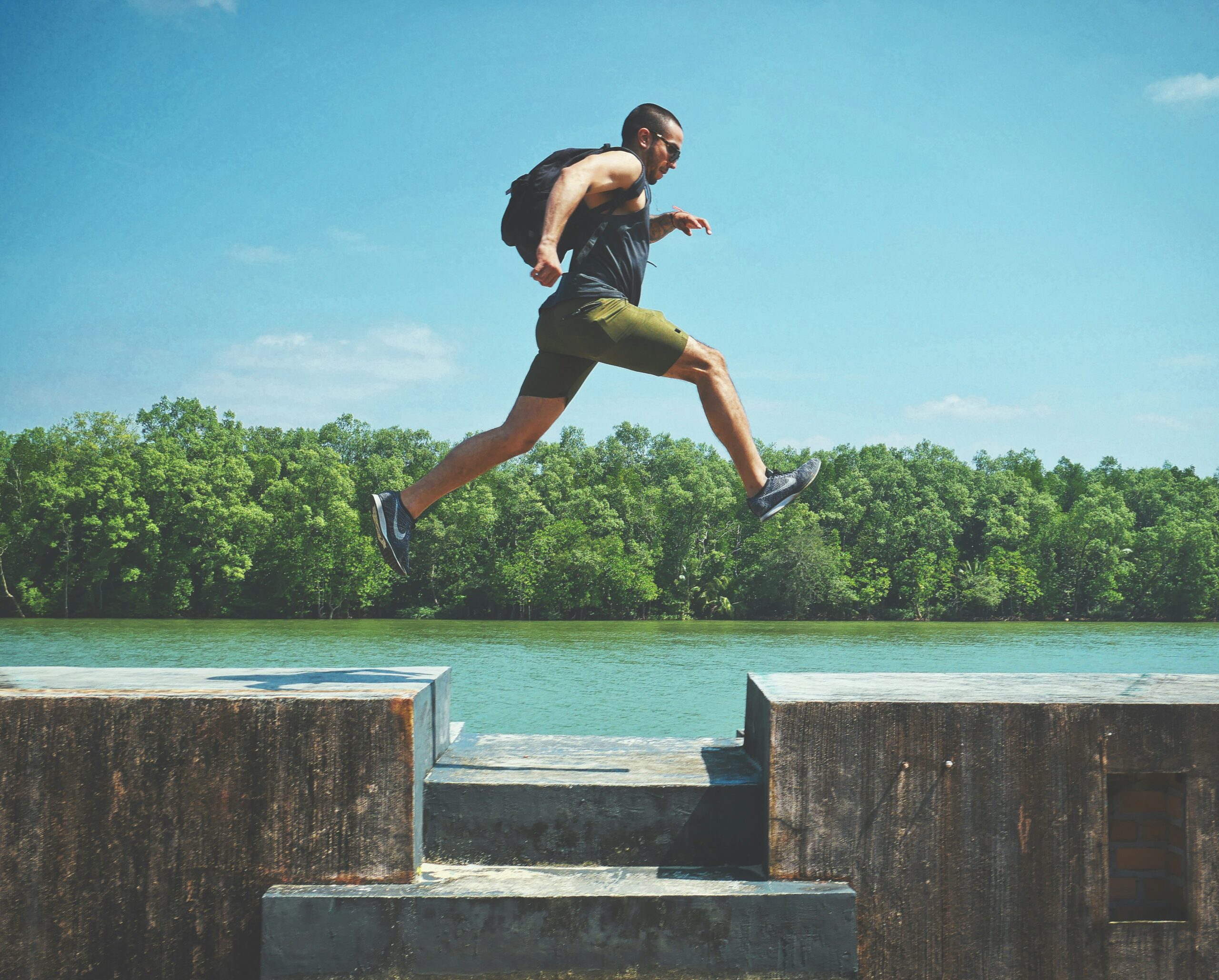 man jumping across river